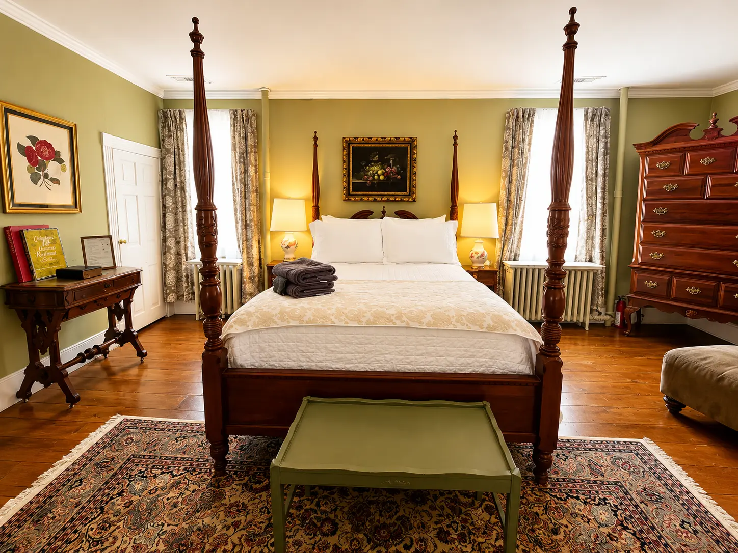 Inviting room with two armchairs, wine, and a four-poster bed.