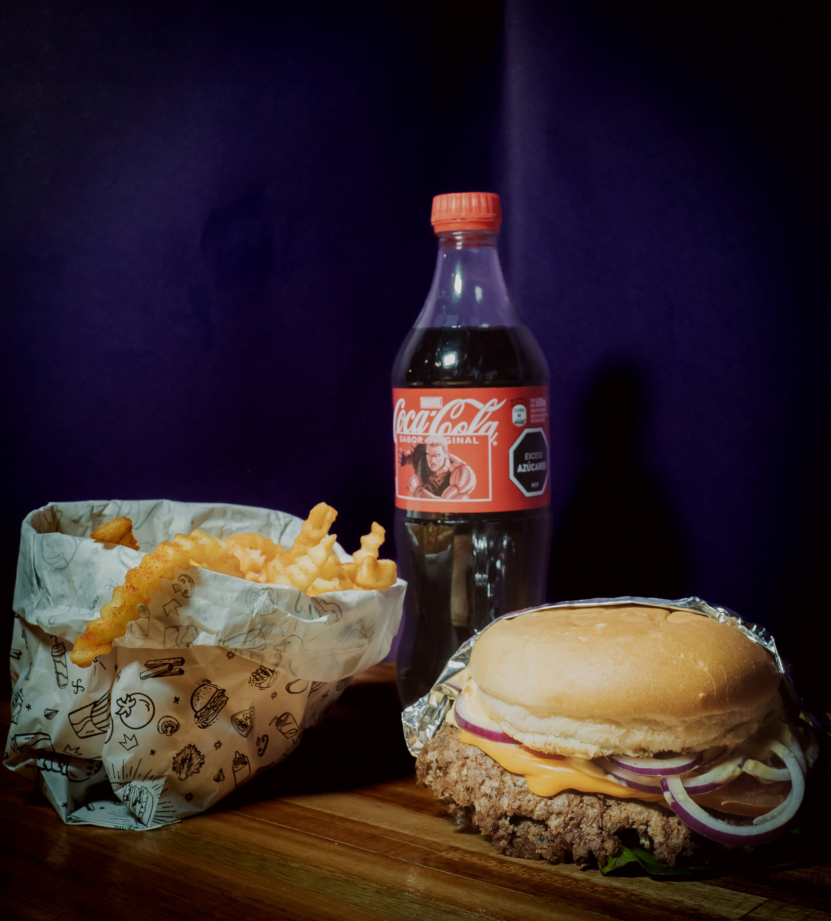 hamburguesa smash con papas fritas crinckle y refreso coca cola.