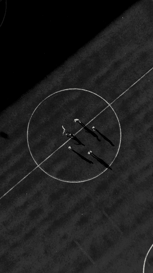 Bride in white dress walking on street, man in background