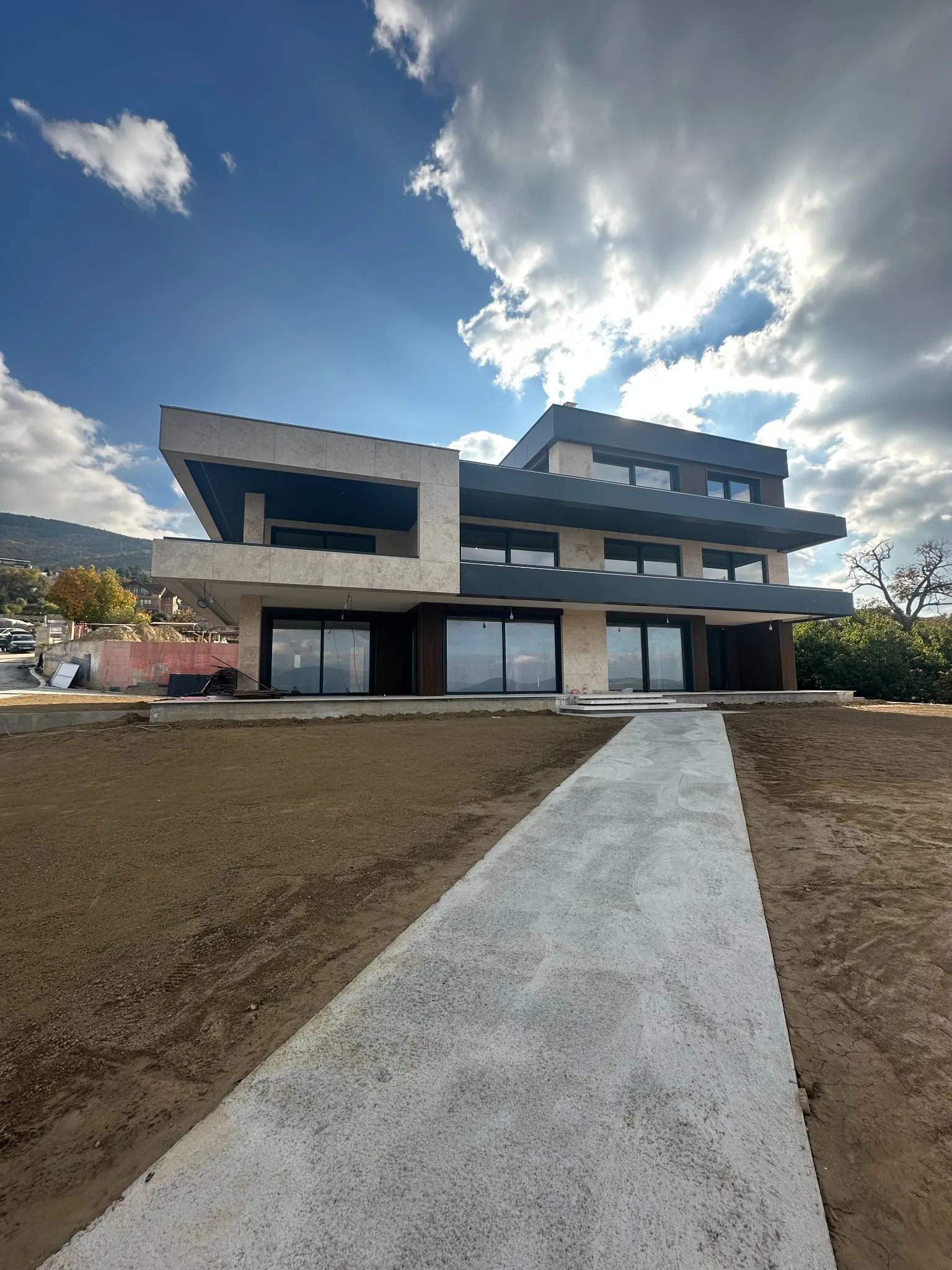 Three-level modern residence Villa Nerezi in Nerez, Skopje, featuring bold cantilevered terraces and large glazing. Architectural planning and supervision by Terraplan Partners.