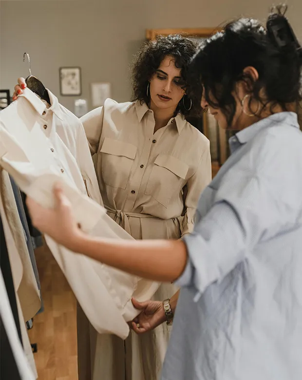 In a fashion buying meeting of kloth source two lady is looking at a woven shirt