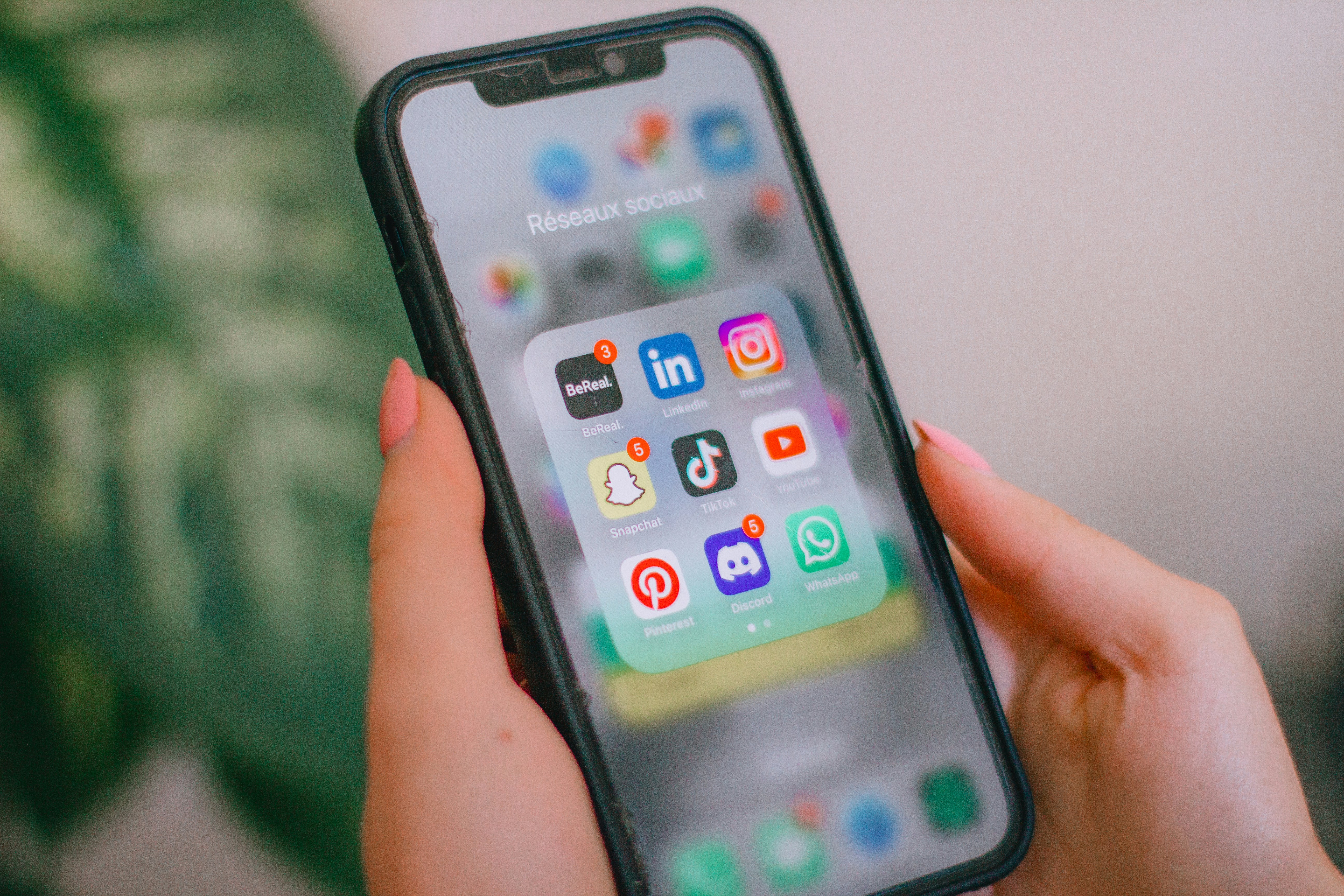 téléphone avec des applications de réseaux sociaux ouvertes : BeReal, LinkedIn, Instagram, Snapchat, TikTok, YouTube, Pinterest, Discord, WhatsApp