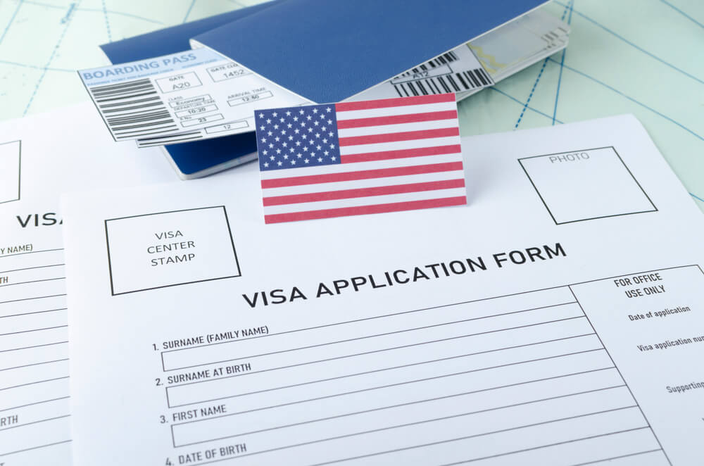 Blank Visa Application form with boarding pass, passport and USA flag