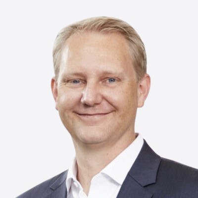 Headshot of employee, Michael Hemicke, on a blue tinted, grey background