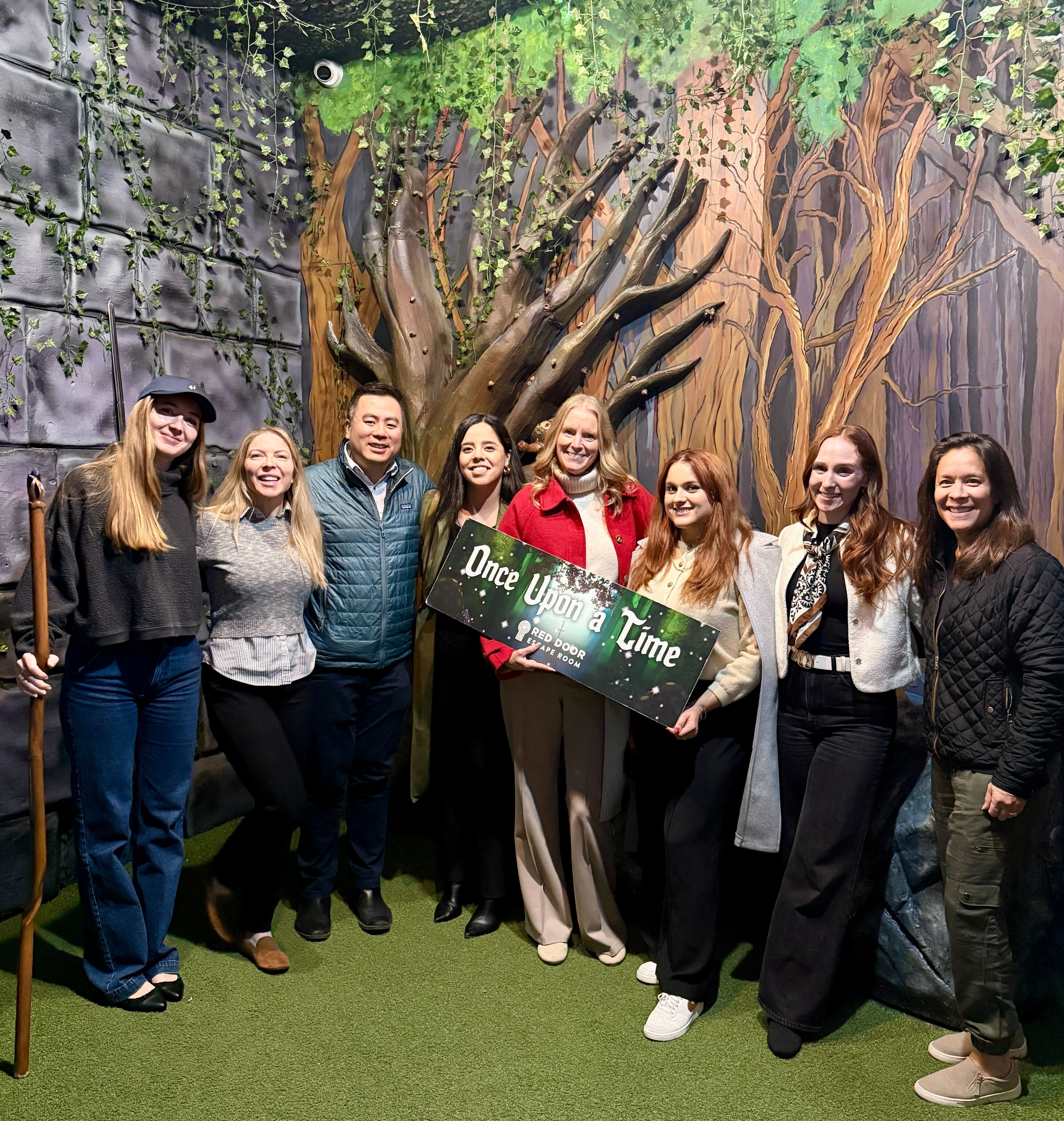 GC AI employees holding a "Once Upon a Time" sign at a fun activity