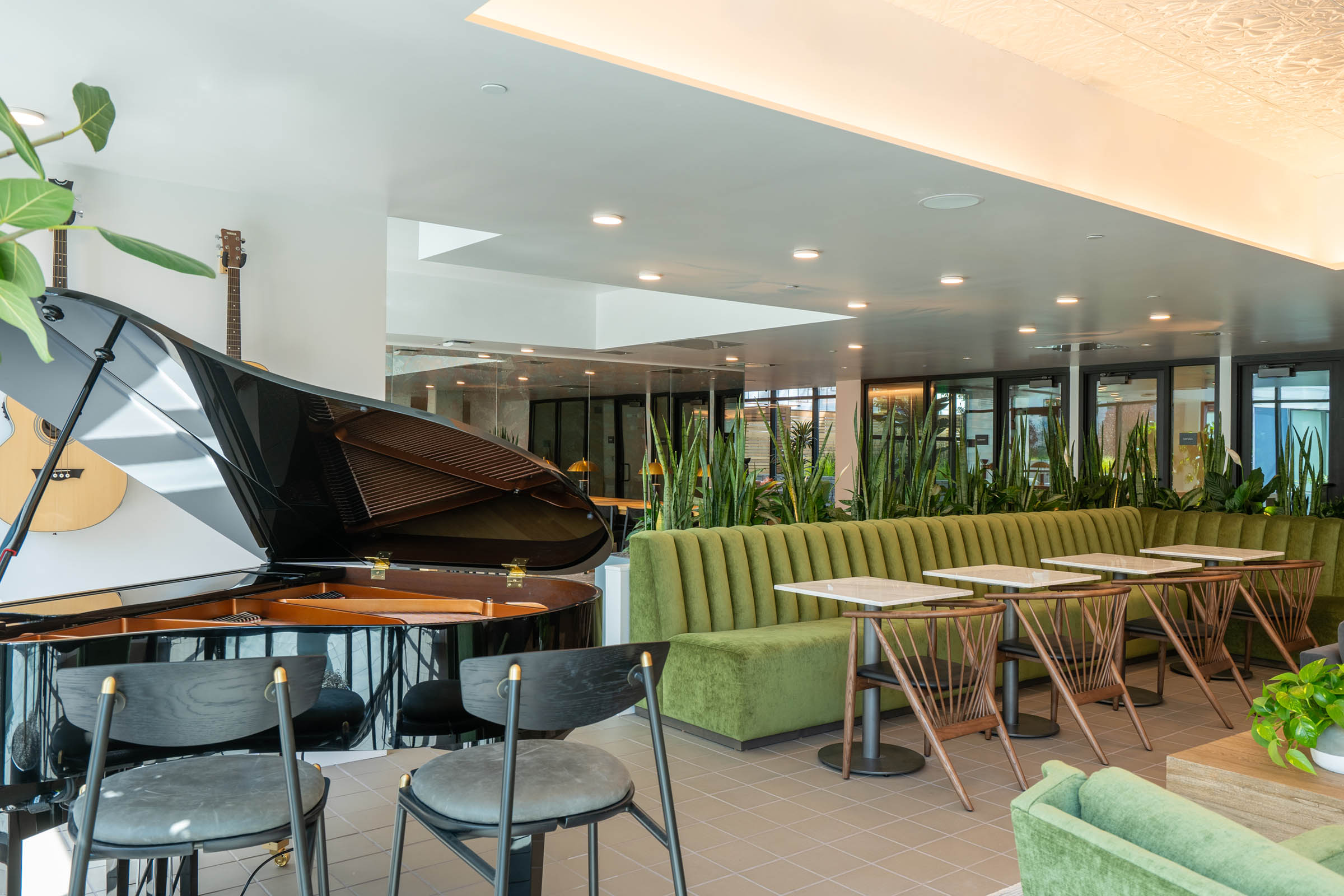 Stylish multi-story apartment building with floor-to-ceiling windows, offering a view of the vibrant neighborhood.