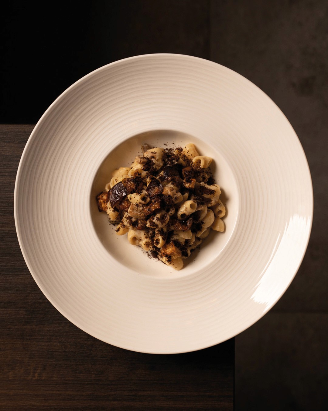 „Hausgemachte Pasta mit sautierten Pilzen und cremiger Sauce, elegant serviert auf einem weißen Teller im Ristorante Giuseppe Gentile.“