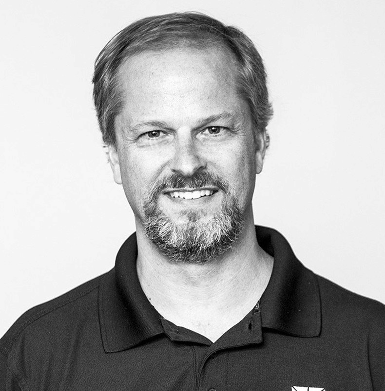 Man with beard and short hair smiling.