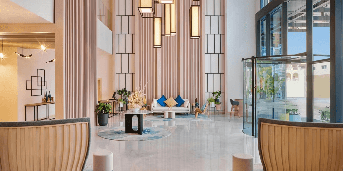 Lobby of voco Dubai The Palm, a bright pet-friendly hotel with airy interiors and modern coastal-inspired décor.