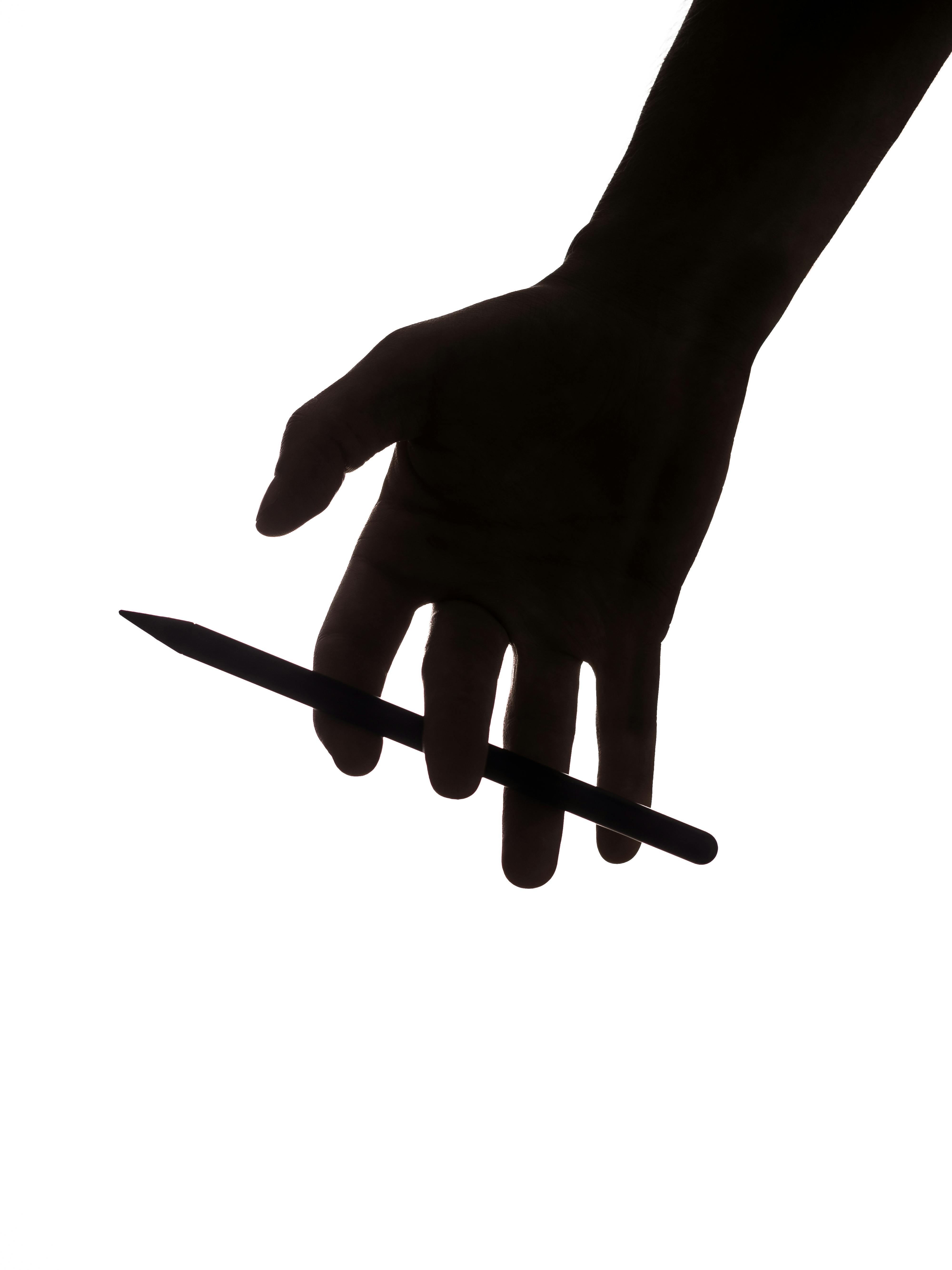 Fingertips extending upward, holding an Apple Pencil.