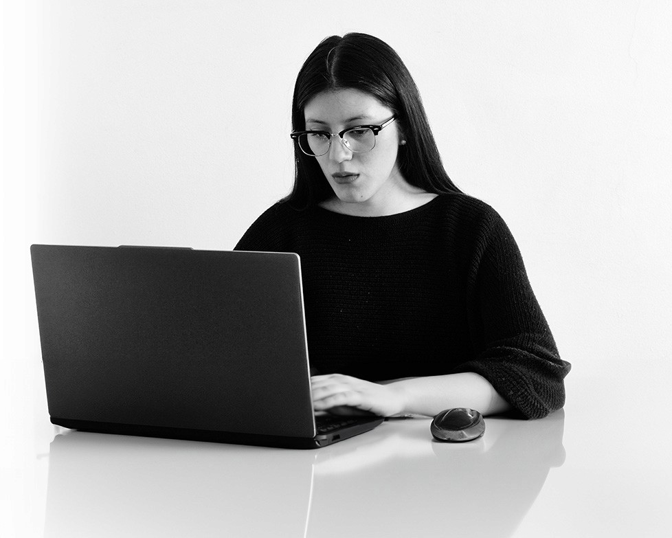 Woman in a light suit sitting thoughtfully against a terracotta wall