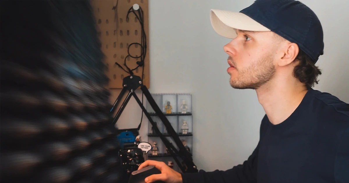 Person, holding a white rose behind his back with one arm on a light blue background