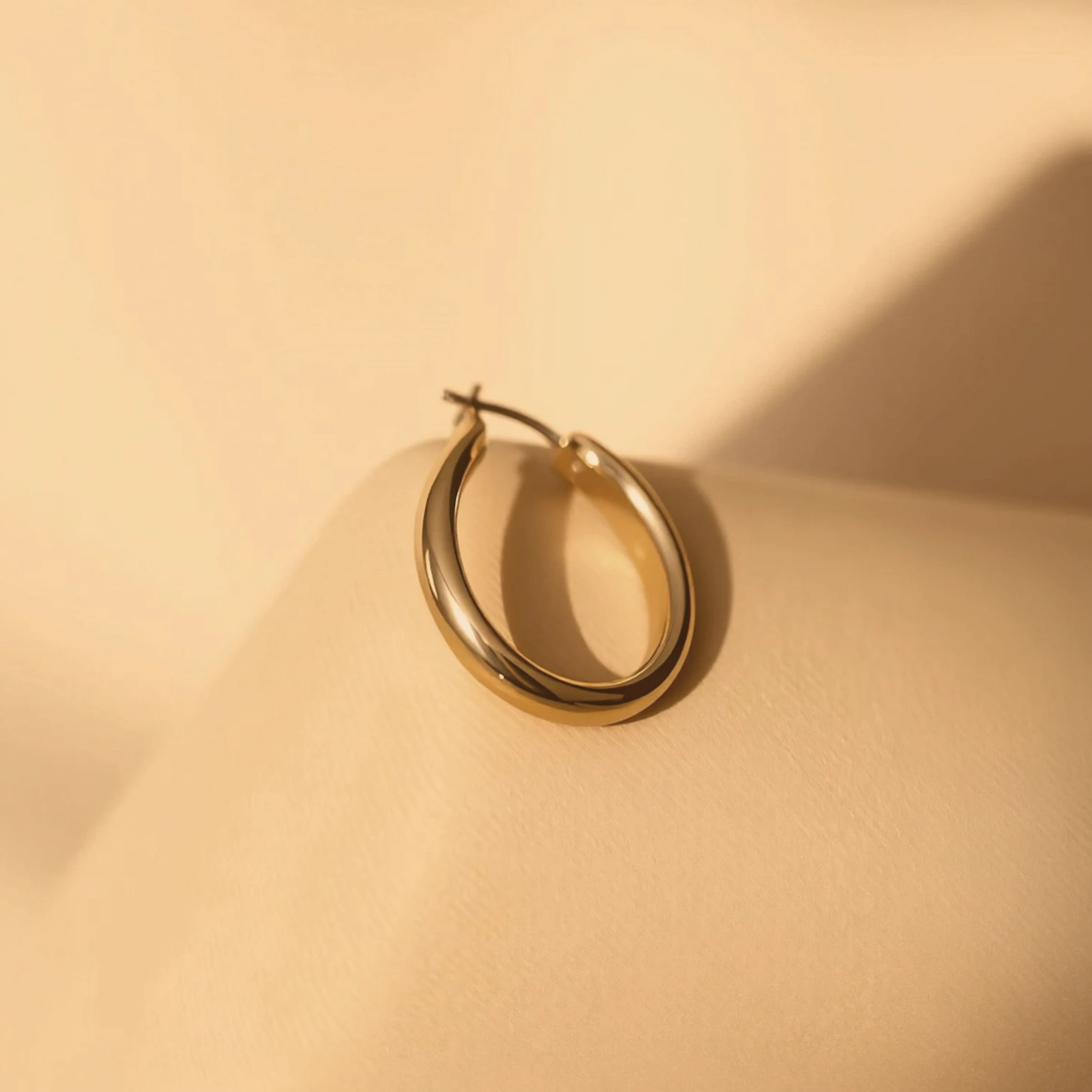Gold Hoop Earring on Textured Pedestal