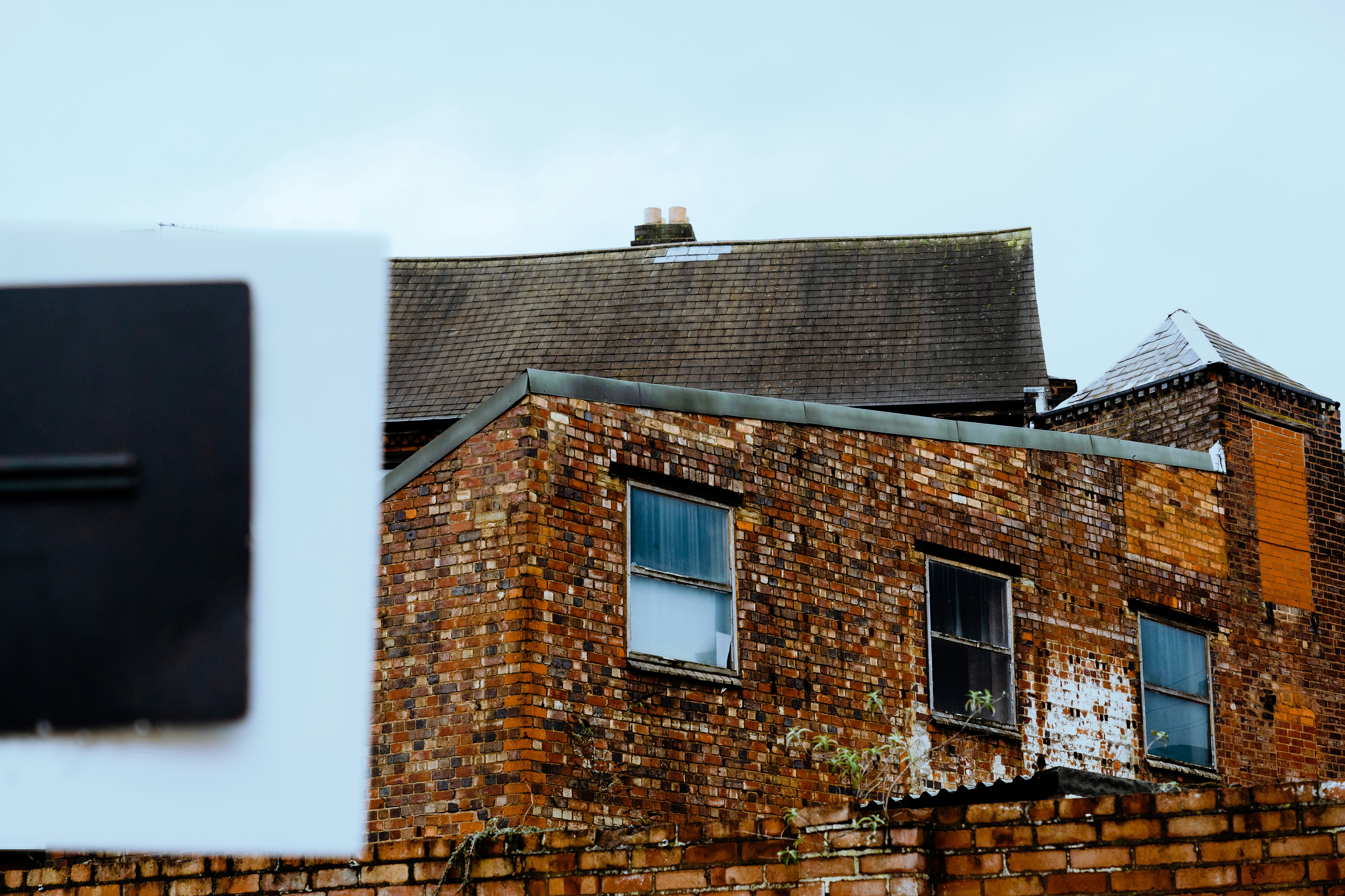 a brick building with a roof and windows