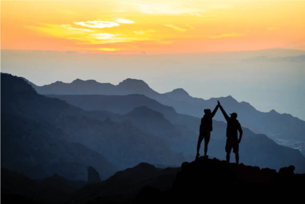 Celebrating successful growth and exit strategies for SMEs with Mountberry, symbolized by two individuals high-fiving on a mountain peak.