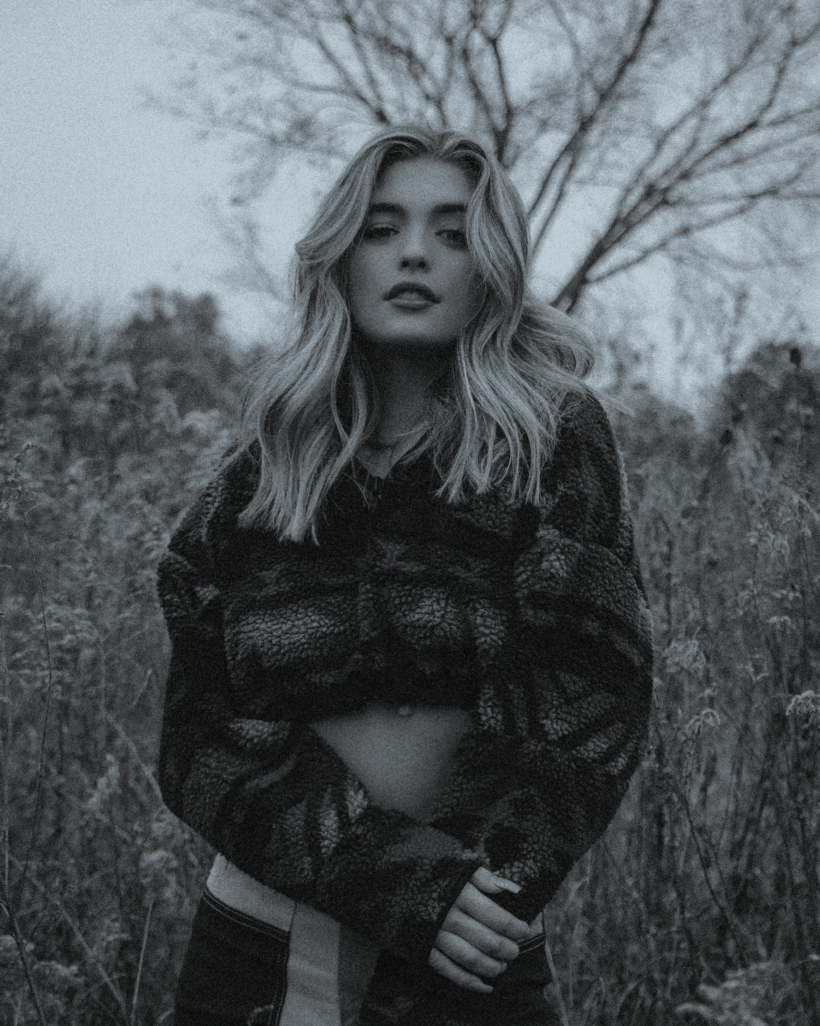 Portrait of a person in a pink sweater against a light background