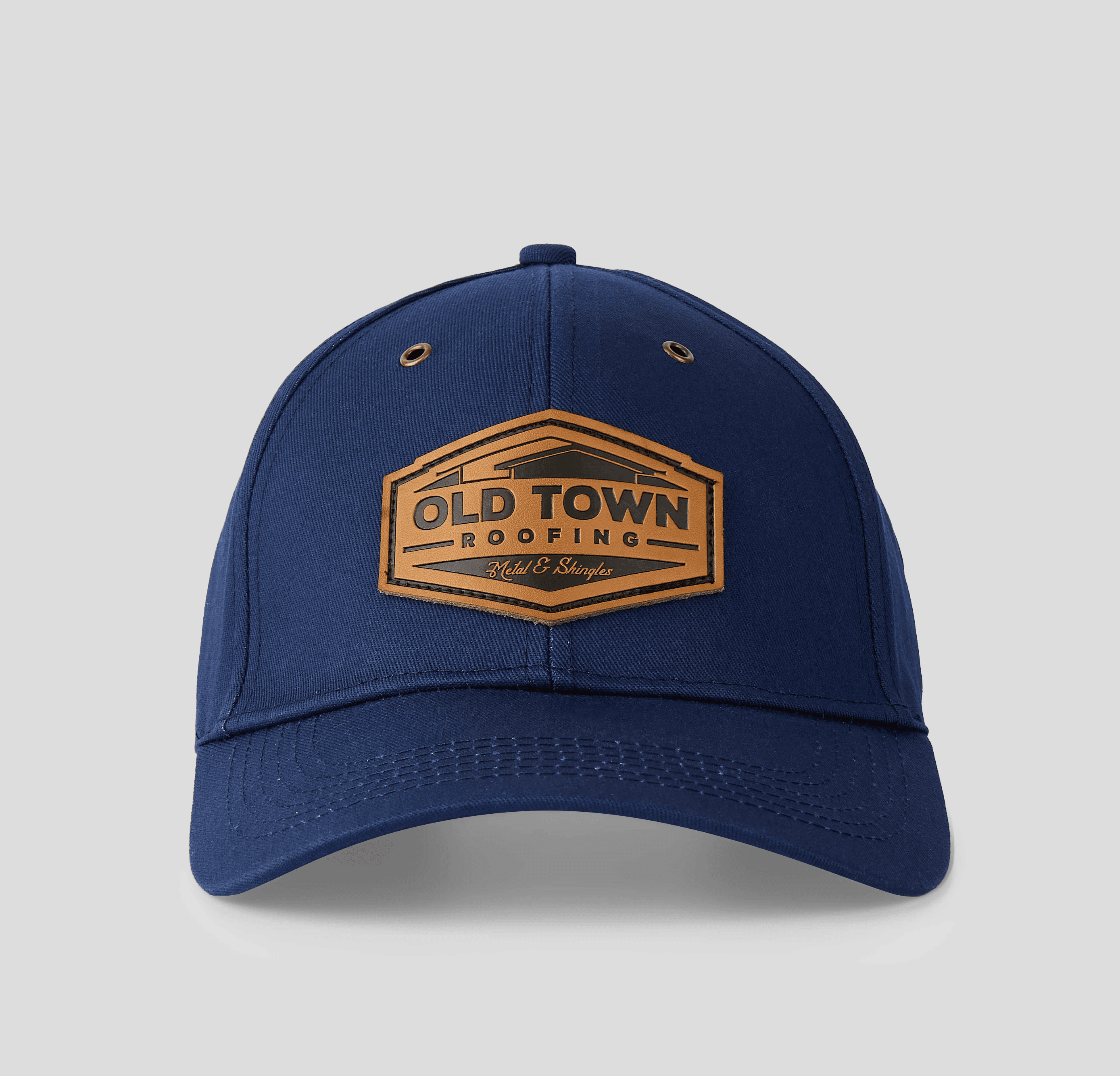 A black baseball cap with a circular embroidered patch featuring red and blue sections, along with white lettering, lies against a light gray background.