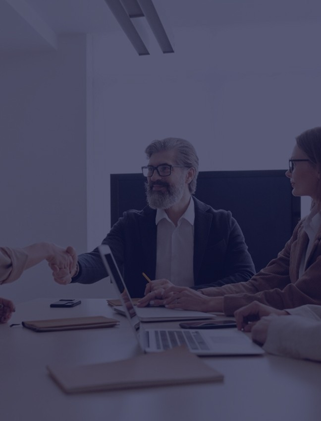 Business meeting with professionals shaking hands at a conference table