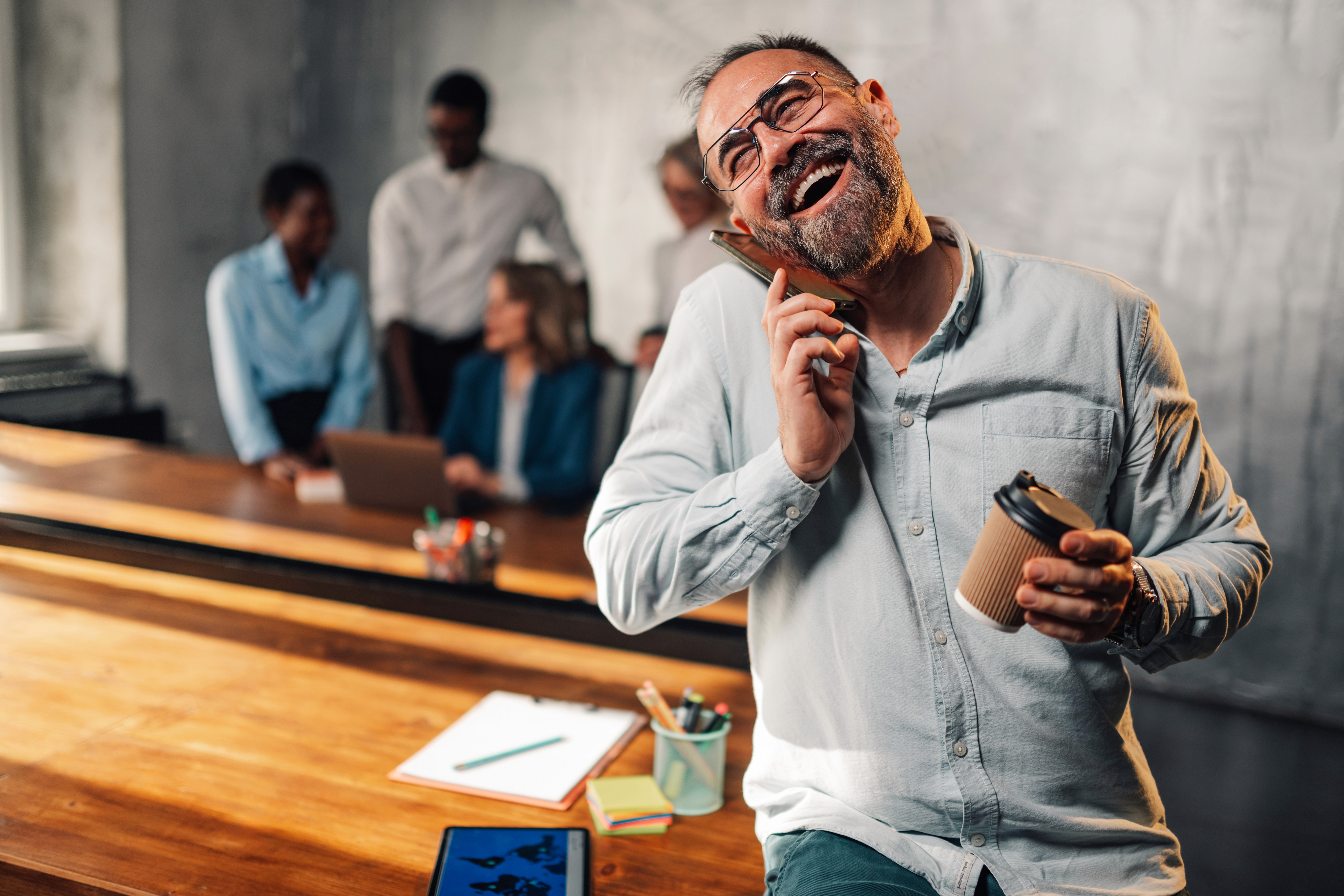 Lachende man aan de telefoon in een werkruimte