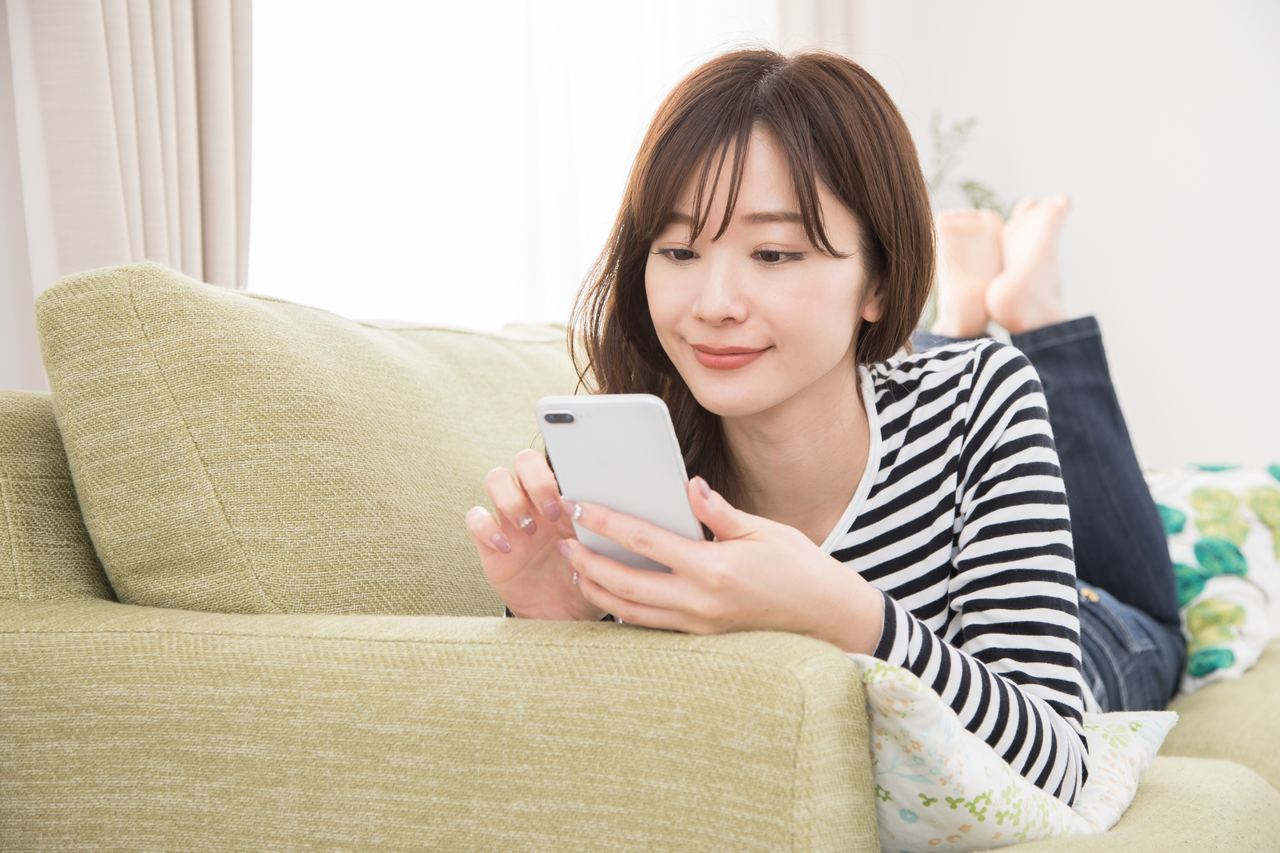 スマートフォンで健康情報を検索する女性。AI要約の表示により検索結果ページだけで完結し、サイトへのクリックが起きないゼロクリック検索の増加を表す