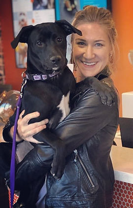 Kim holding her black dog Sophie 
