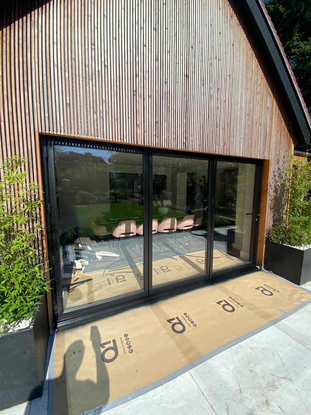 Open glass doors reveal a lush green courtyard garden.