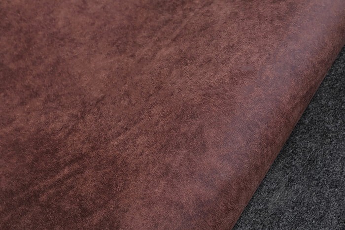 Close-up of leather wallet being hand stitched with waxed thread – traditional leatherworking