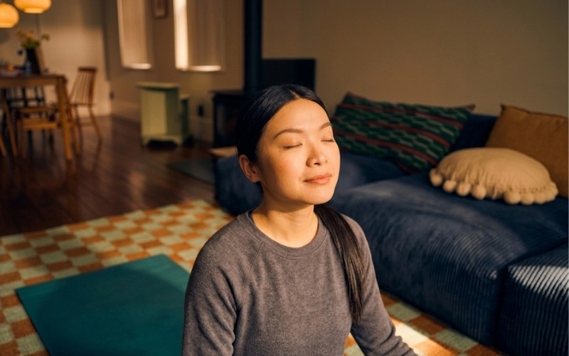 Person meditating indoors as part of a productive morning routine&nbsp;