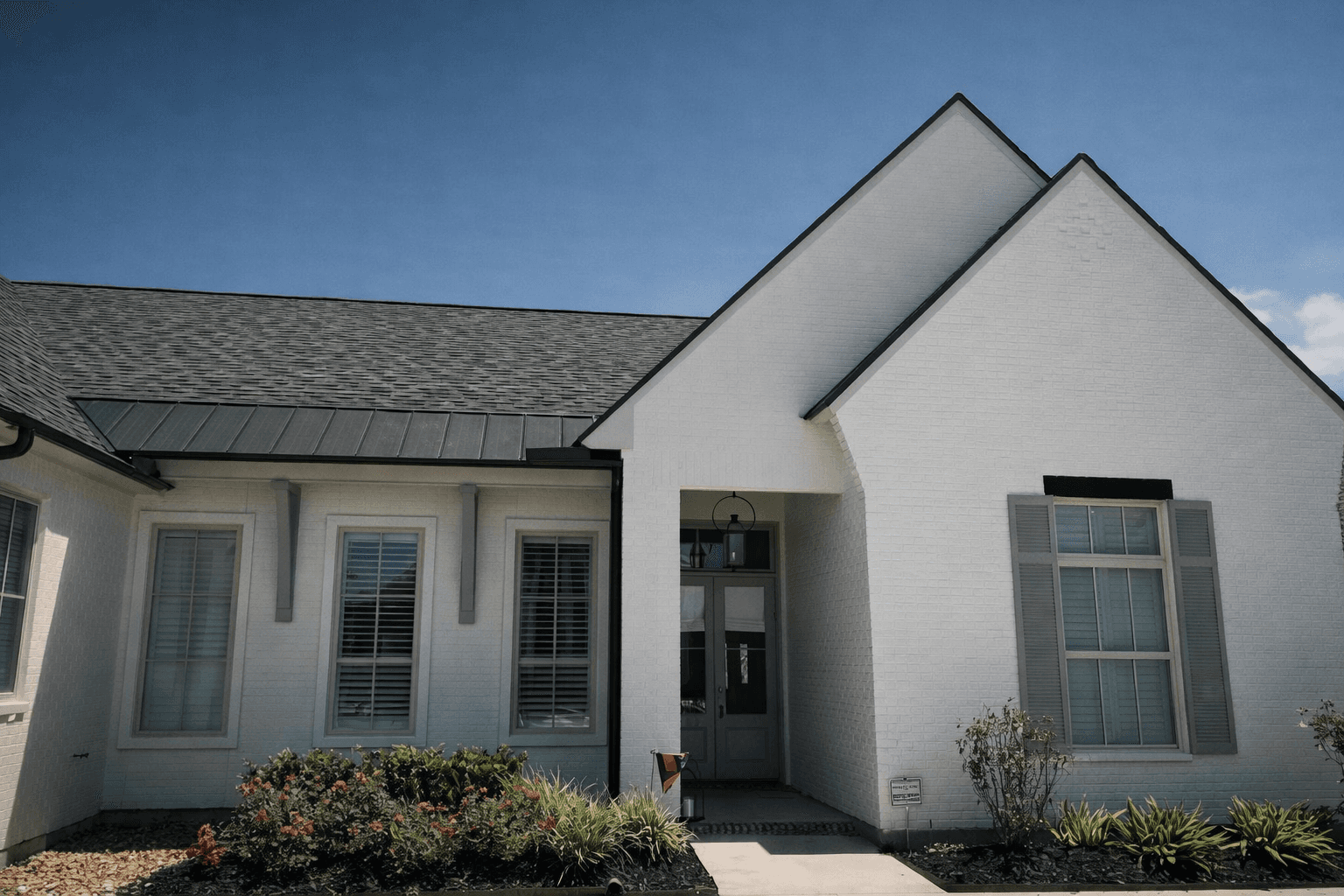 Spacious, luxurious living room with high ceilings, an elegant beige sectional sofa, warm ambient lighting, classical artwork, and rustic architectural elements, featuring an open layout with a view of a mezzanine level.