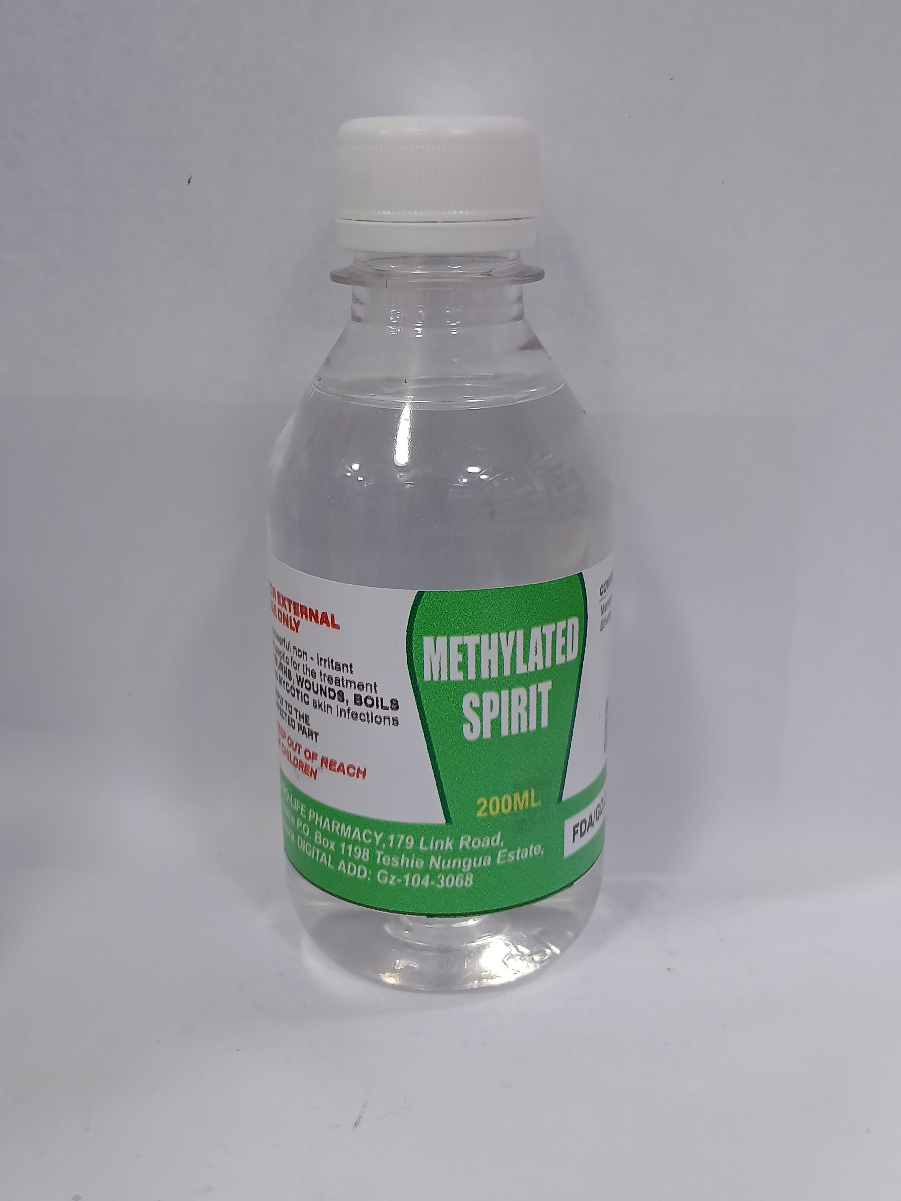 A clear plastic bottle with a white cap contains a liquid, featuring a green and white label with printed text and a small red and white logo near the bottom.