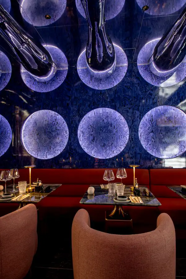Moon Lounge: glowing lapis-blue discs above the tables