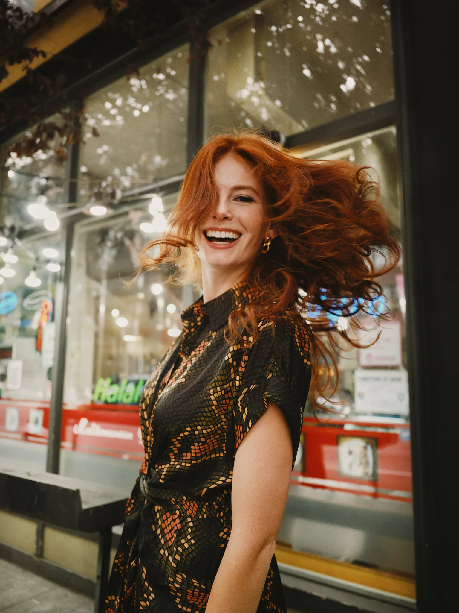 redhead flipping hair laughing on sidewalk — portrait photography by Tom Kubik