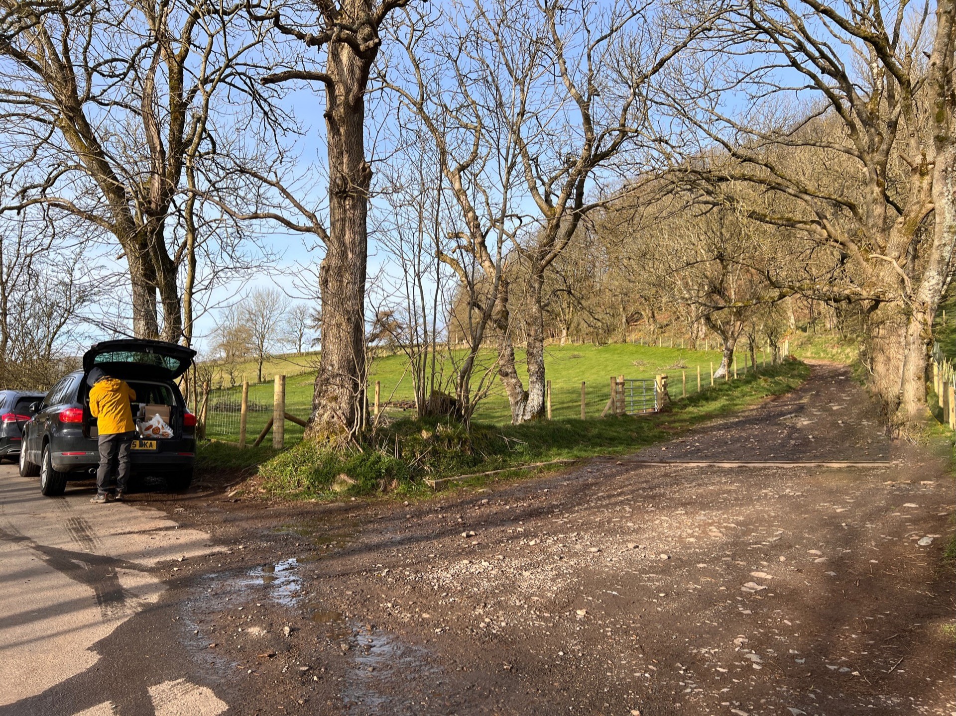 Marting is seen in the back of the car getting ready. To the right is the path that leads to the start of Great Mell Fell.