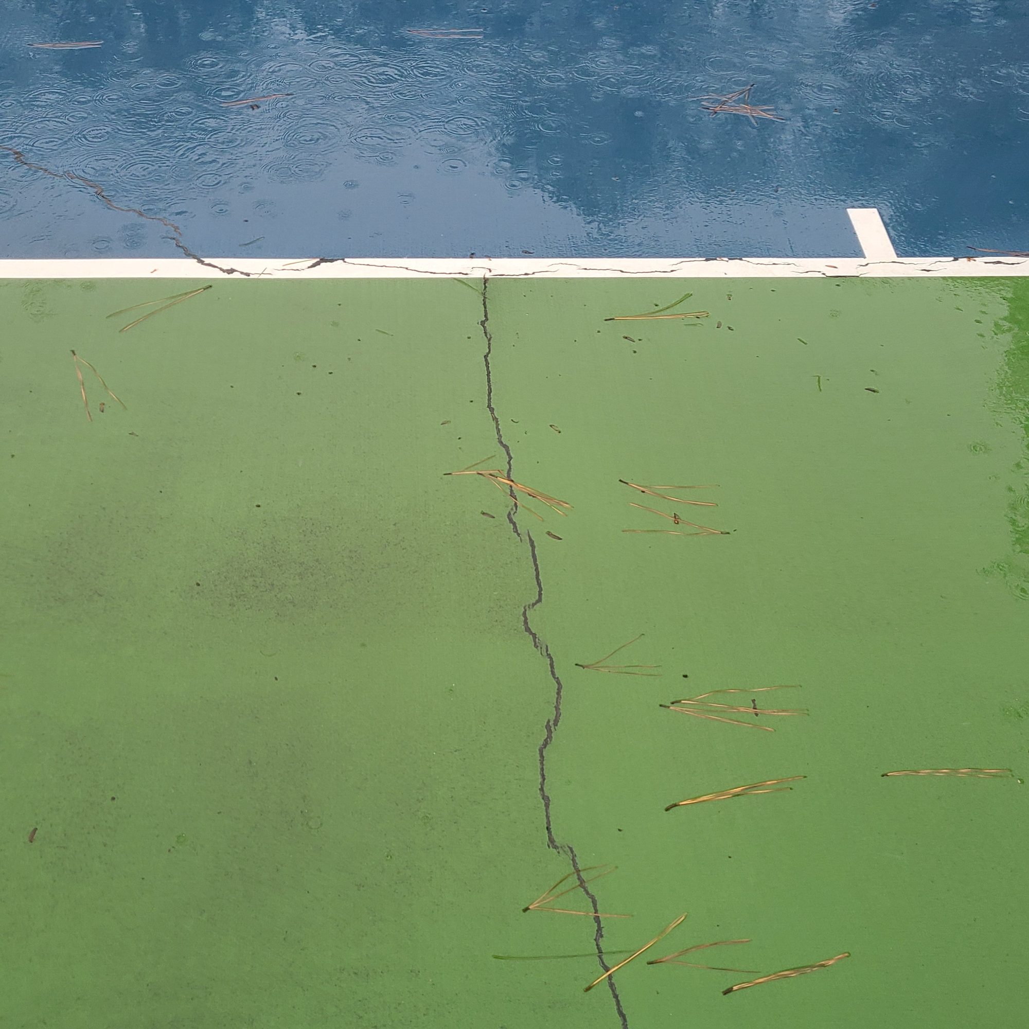 Long crack through the green surround before resurfacing at Rebsamen Tennis Center in Little Rock, AR