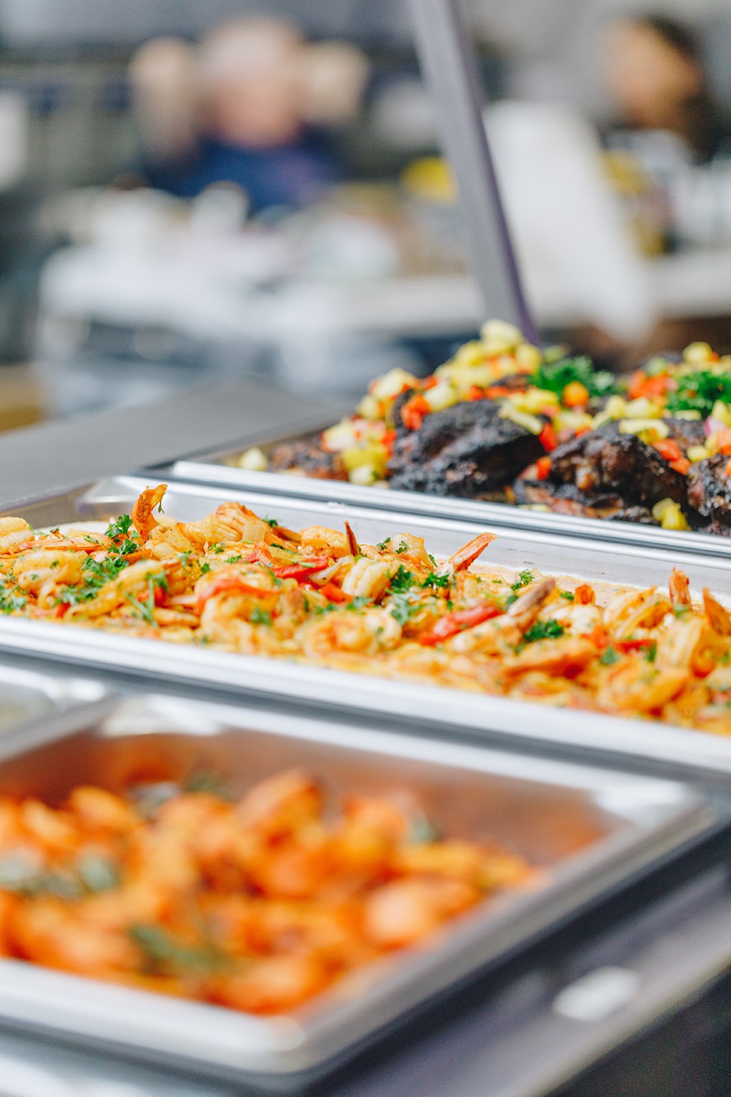 A buffet display featuring trays of colorful, cooked vegetables and various side dishes.