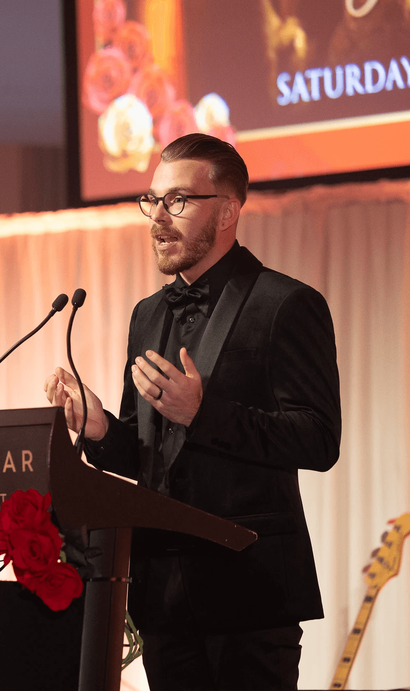 Nathan giving a presentation at a charity awards night