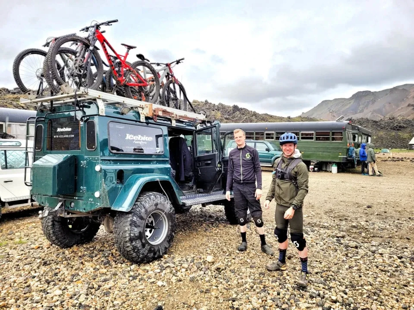 David the guide in front of a green Landrover defender with a lot of bikes on top of it