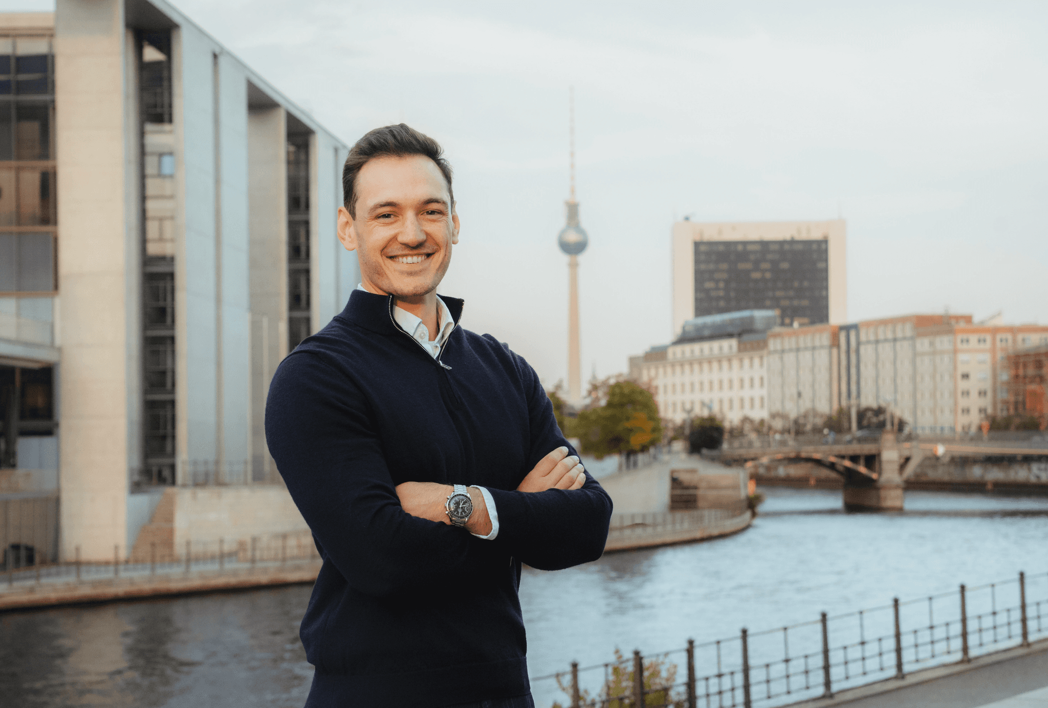 Guy standing in front of a river, berlin skyline