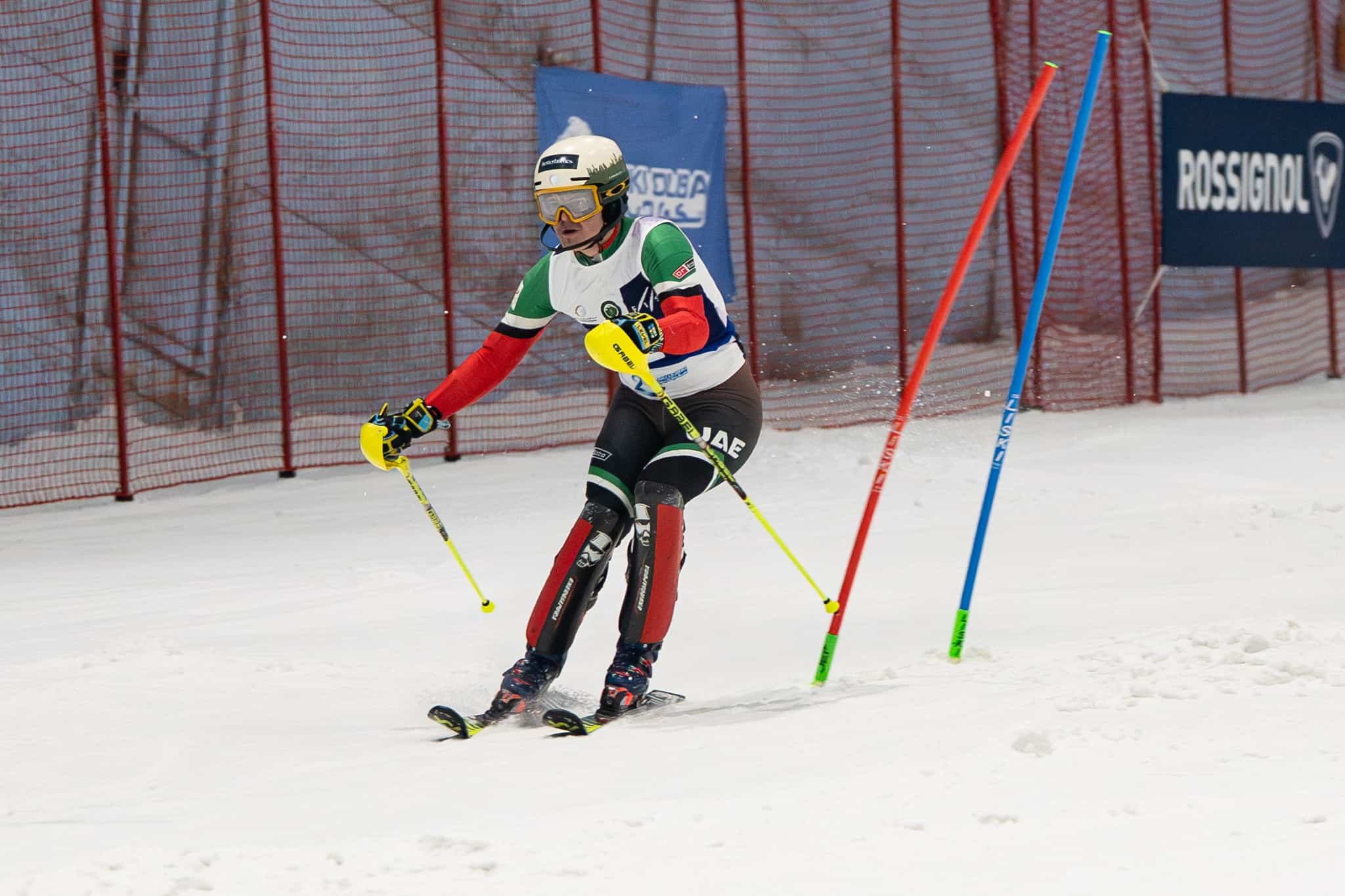 A man wearing safety gear and a helmet skiing down the slope at Ski Dubai, a fun activity for things to do in Dubai with family.