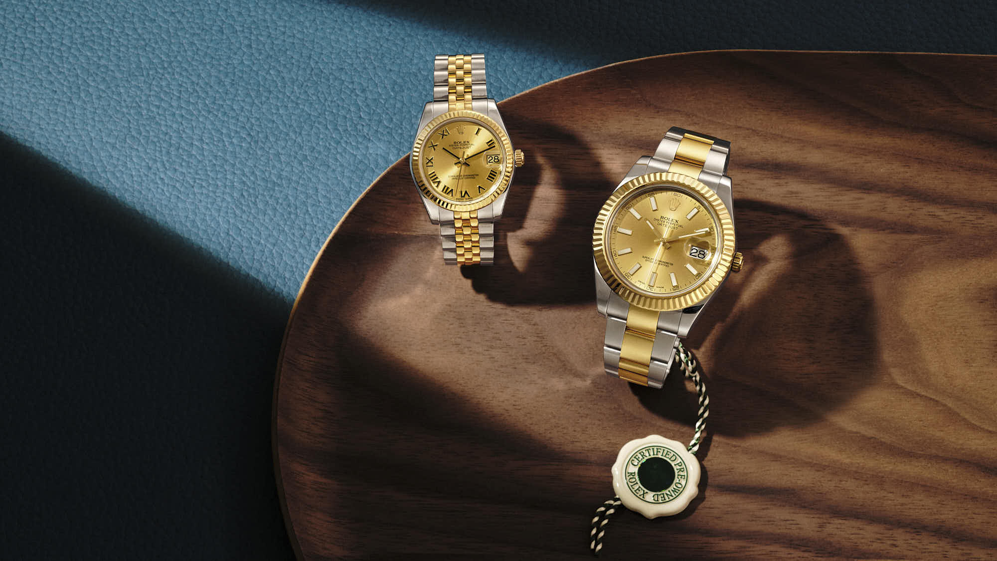 Luxury gold and stainless steel watches on wooden surface, premium timepieces.
