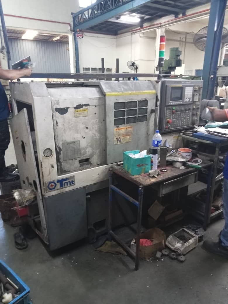 Before 5S implementation: CNC lathe machine in the factory floor showing clutter and disorganized workstation.