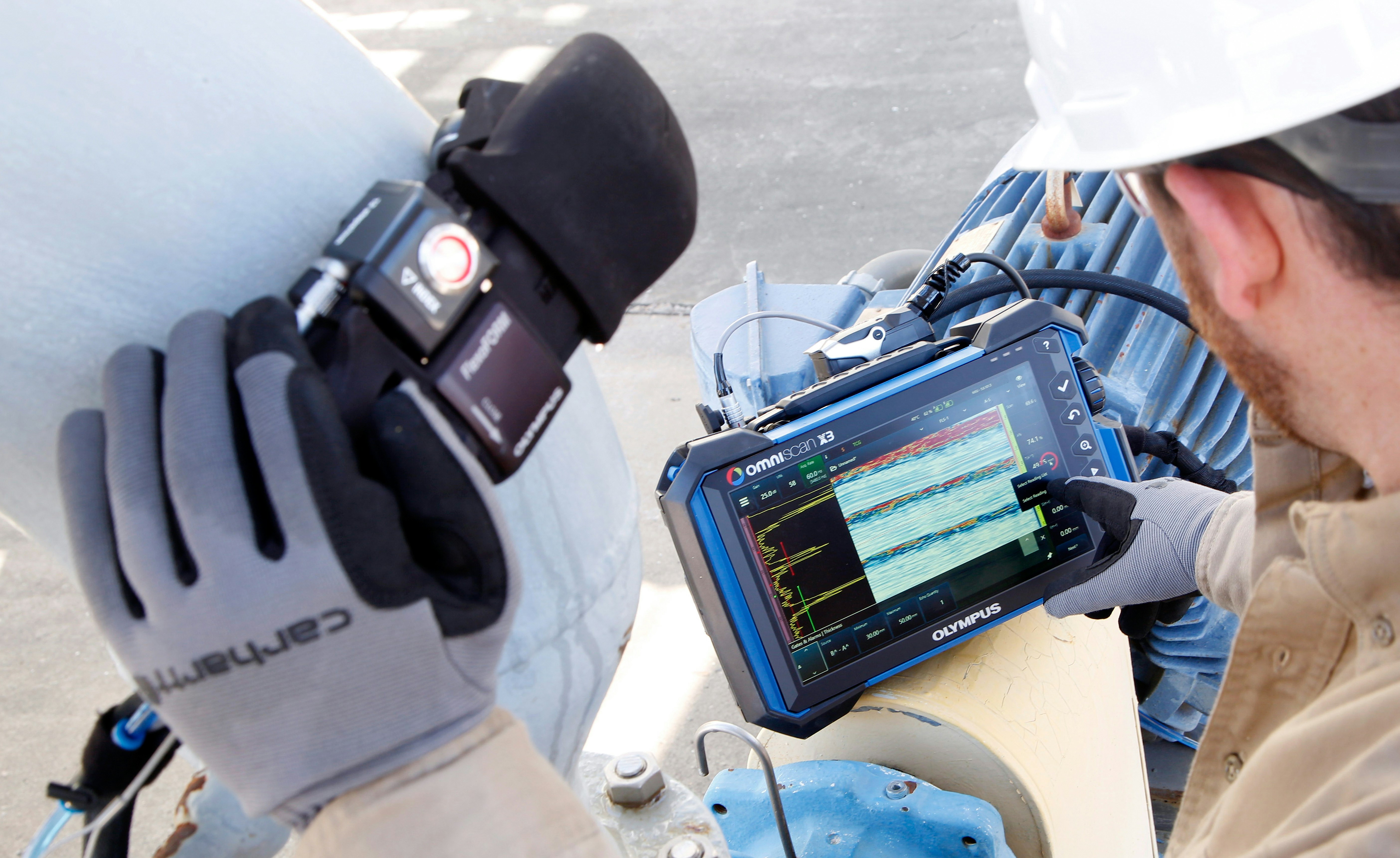 a man in a hard hat is looking at a computer screen
