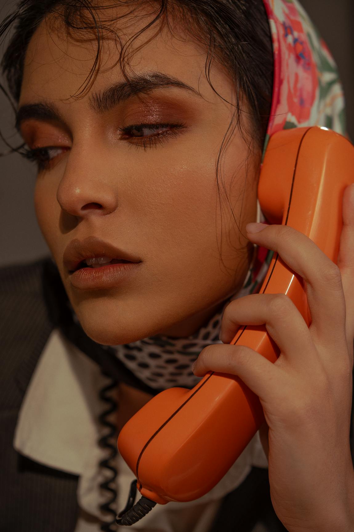Woman in headscarf with vintage orange phone
