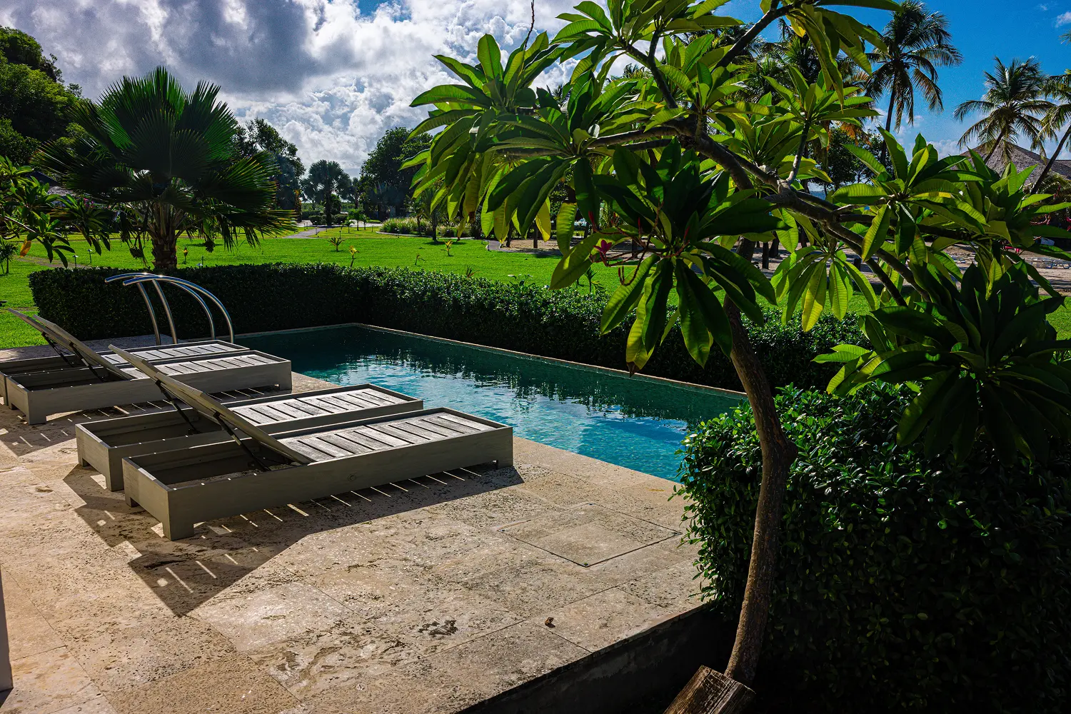Person standing in calm ocean water at sunset, silhouetted against golden light