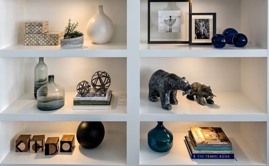Image of Luxury home design with decorative objects, books, and vases on built-in shelving by KHD Homes.