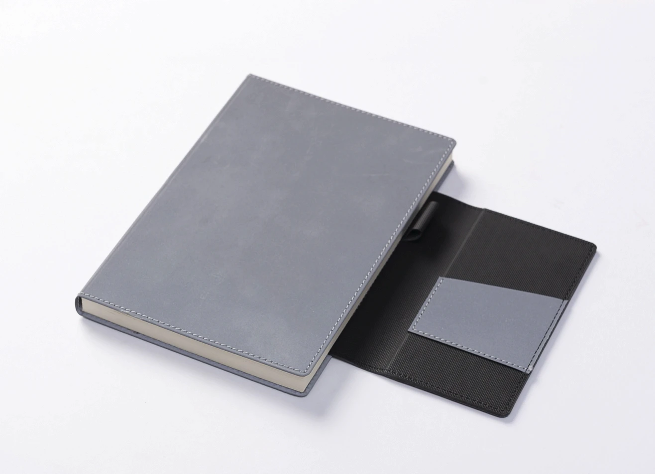 Grey notebook with open magnetic flap and pen loop.