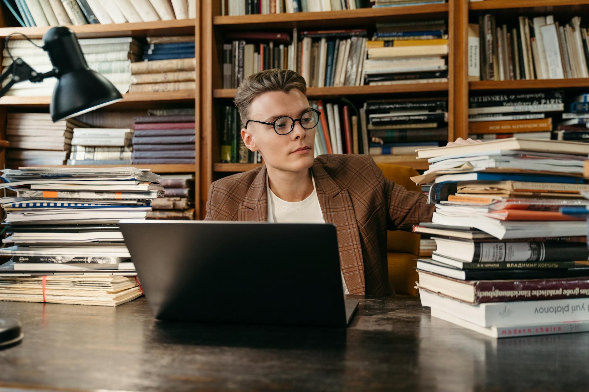 A professional educator reads through a formal certification document and school policy handbook in an office.