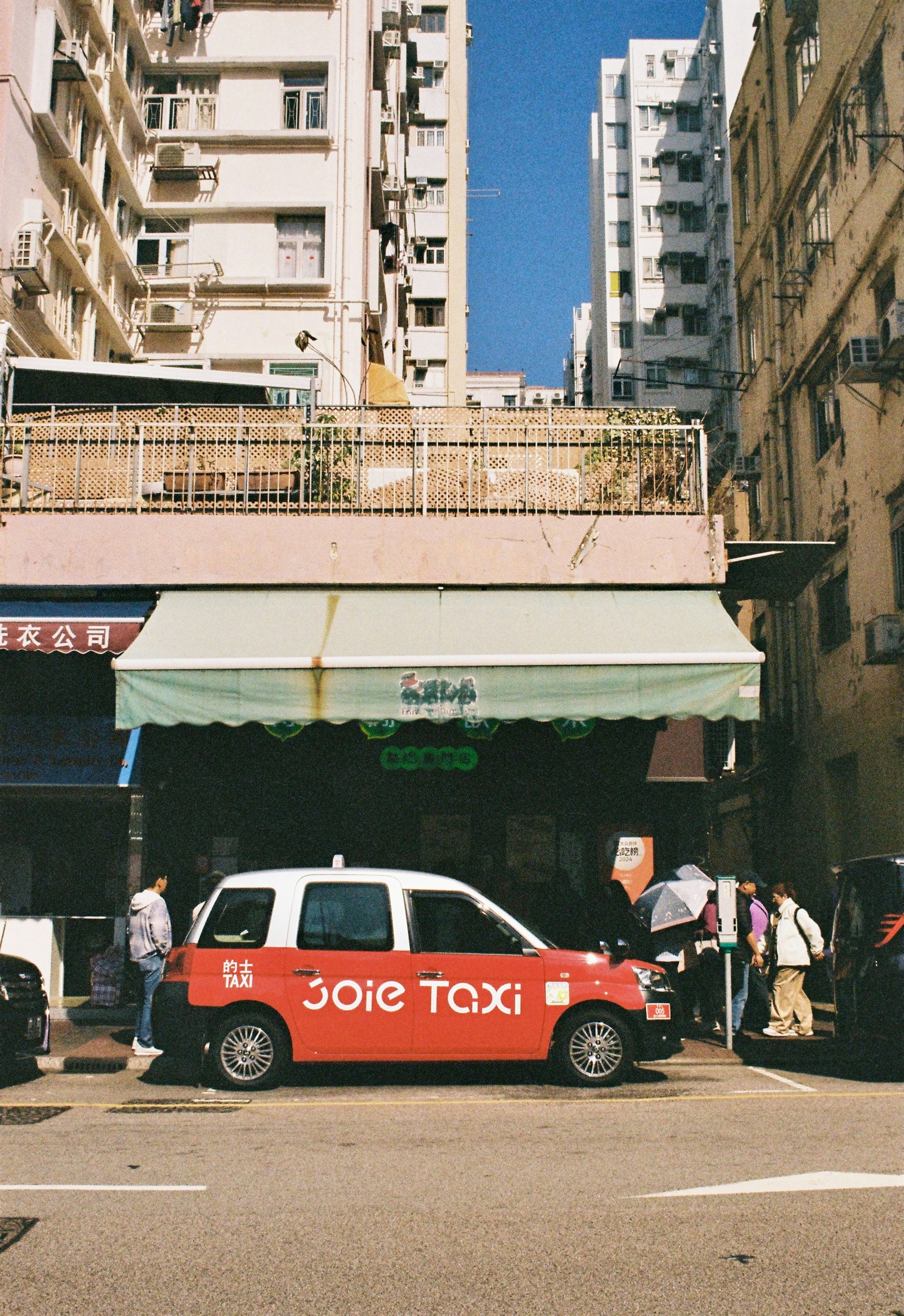 A red and white taxi parked on a city street.