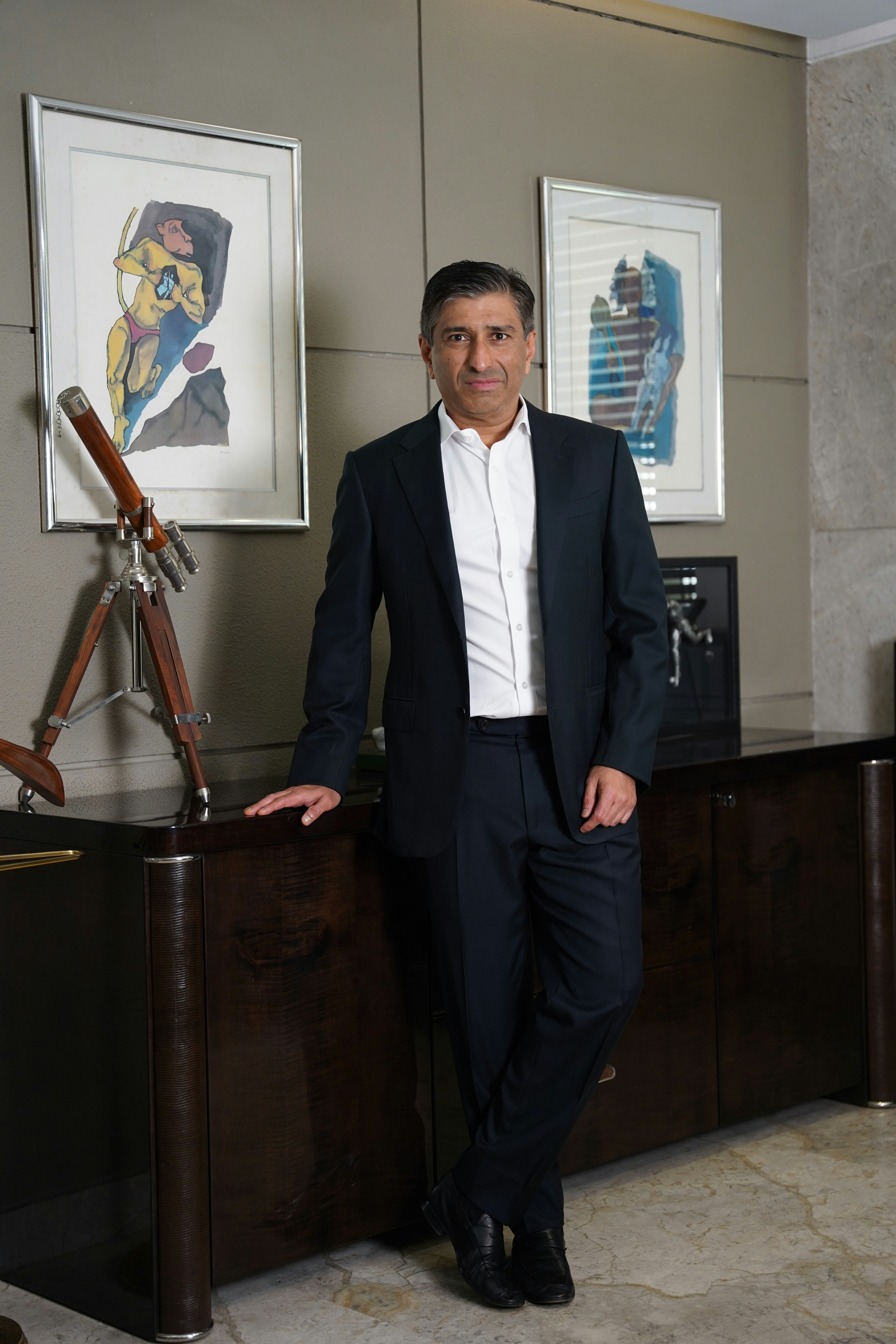 Man in suit poses in an elegant office.
