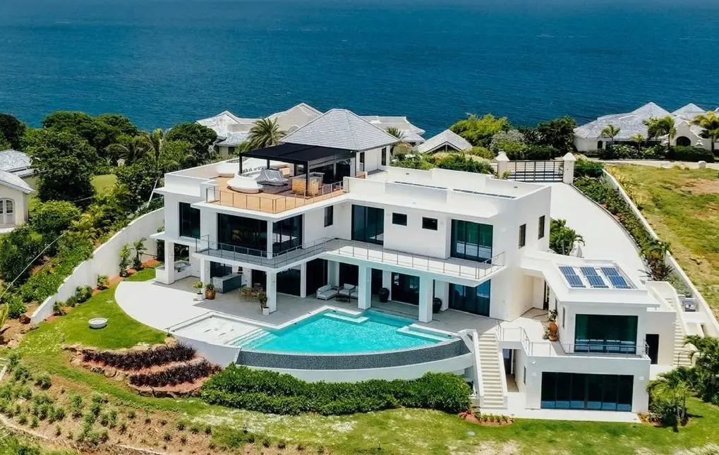 Hillside oceanfront luxury residence by Atelier International with infinity pool, rooftop terrace, and panoramic Caribbean sea views.